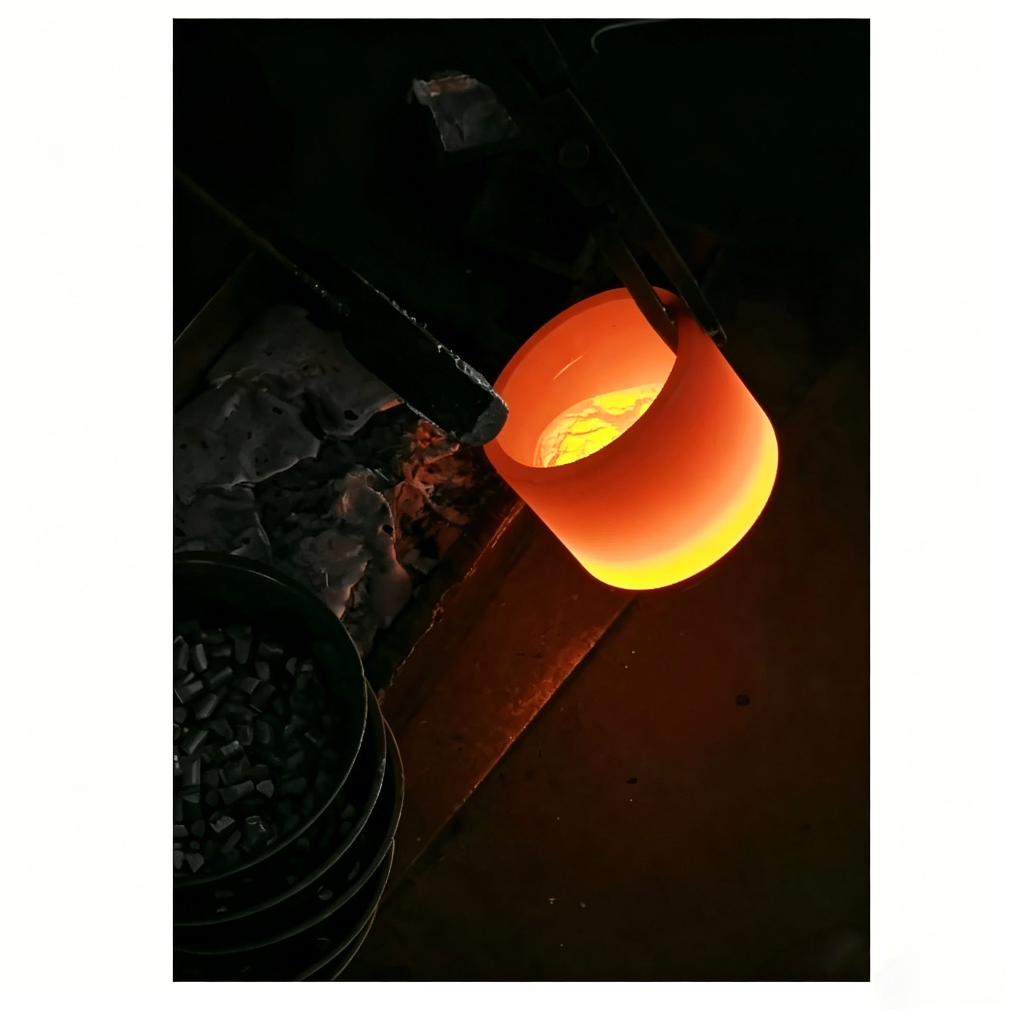 Crisol de grafito brillante que contiene aluminio fundido, utilizado en el proceso de recubrimiento por evaporaci&oacute;n al vac&iacute;o, lo que demuestra una excelente estabilidad t&eacute;rmica y resistencia a la corrosi&oacute;n.